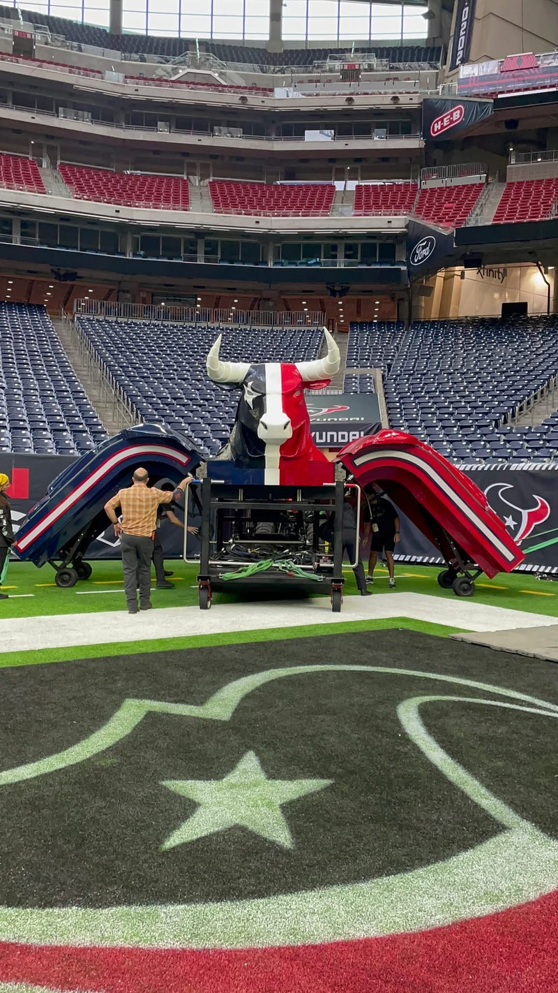 The Houston Texans bull entrance being assembled on the field at NRG Stadium, with red and blue armored arches on each side